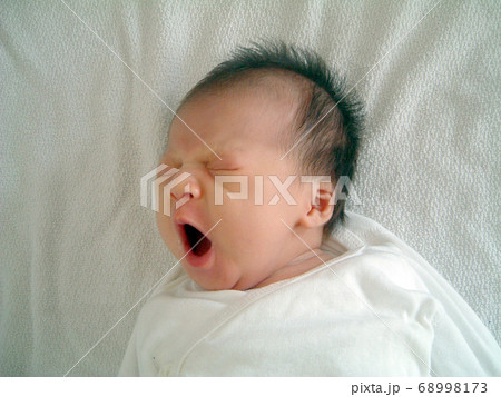 あくびをする生まれたての赤ちゃんの写真素材