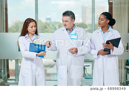 Experienced doctor helping interns Experienced doctor helping interns 68998349