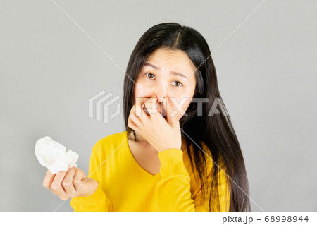Fever,Young Asian woman wearing yellow shirt,Have a cold, wipe the snot isolated on gray background,health care concept 68998944