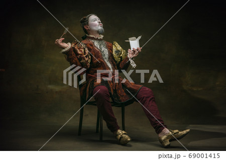 Young man as Johann Sebastian Bach on dark green background. Retro style, comparison of eras concept. Young man as Johann Sebastian Bach on dark green background. Retro style, comparison of eras concept. 69001415