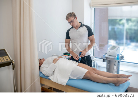 Doctor providing a procedure to his patient 69003572