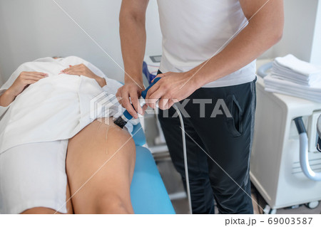 Man providing a beauty procedure to his client Man providing a beauty procedure to his client 69003587