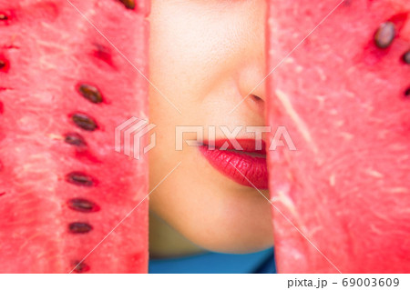 Lips between slice of watermelon. 69003609