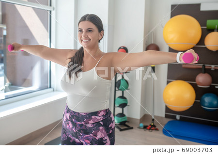 Woman doing exercises with dumbbells in gym 69003703