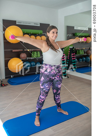 Plus-sized woman practising yoga asanas in a gym Plus-sized woman practising yoga asanas in a gym 69003708