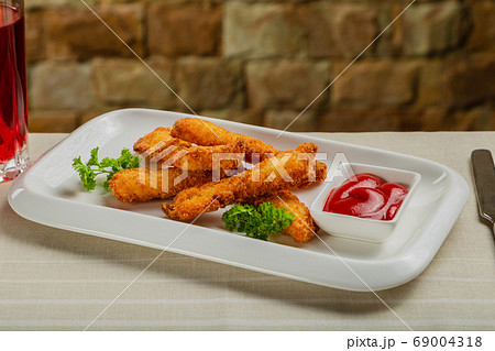 Fresh crispy nuggets with tomato sauce on a white 69004318