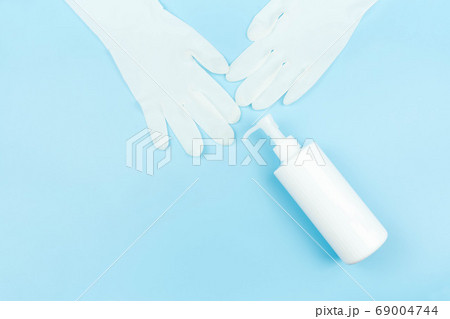 white latex medical gloves and spray alcohol isolated on blue background ,health care concept 69004744