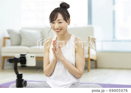 ビデオ撮影をするトレーニングウェアの女性 ヨガ 69005076
