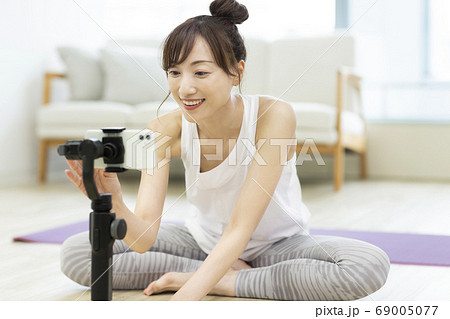 ビデオ撮影をするトレーニングウェアの女性 ヨガ 69005077