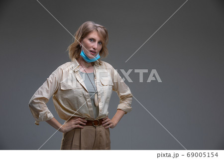 Blond woman take off her surgical mask 69005154