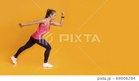 Motivated Young Woman In Sportswear Running Over Yellow Background 69006284