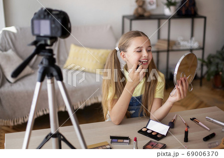 Smiling Girl Applying Makeup, Recording Her Beauty Blog Smiling Girl Applying Makeup, Recording Her Beauty Blog 69006370