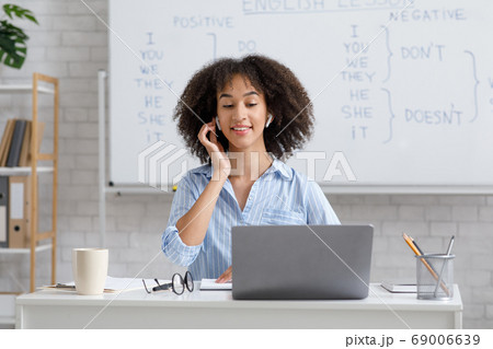 English tutor remotely. Attractive woman with wireless headphones looking at laptop English tutor remotely. Attractive woman with wireless headphones looking at laptop 69006639