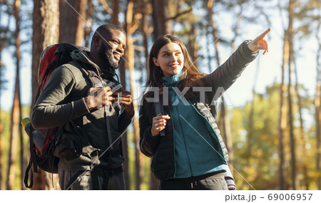 Mixed race couple of hikers walking by forest Mixed race couple of hikers walking by forest 69006957