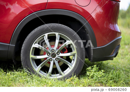 Rear wheel of a red car that is parked in the Rear wheel of a red car that is parked in the 69008260