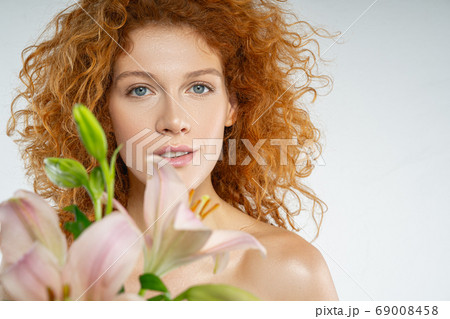 Lovely red-haired lady posing on the gray background 69008458