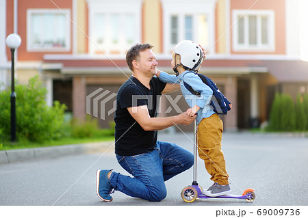 Little boy with scooter says goodbye and hugging 69009736
