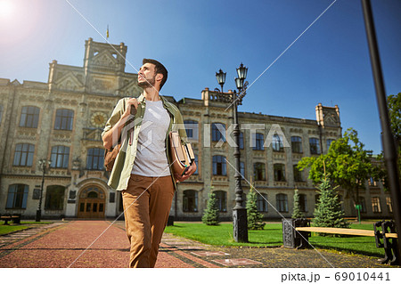 Male student looking up at the sky Male student looking up at the sky 69010441