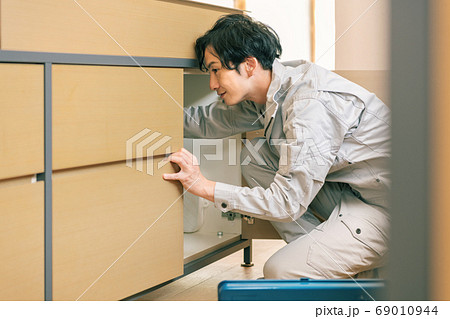 シンク下のトラブルを修理する水道業者 69010944