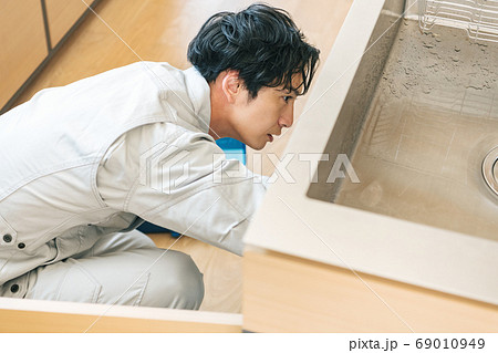 シンク下のトラブルを修理する水道業者 69010949