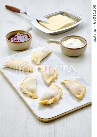 Cherry vareniki on marble serving board with Cherry vareniki on marble serving board with 69011209