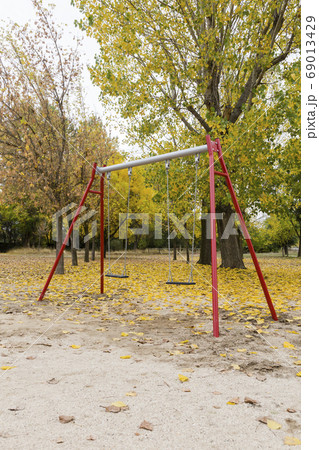 swings in a park with yellow fallen leaves of swings in a park with yellow fallen leaves of 69013429