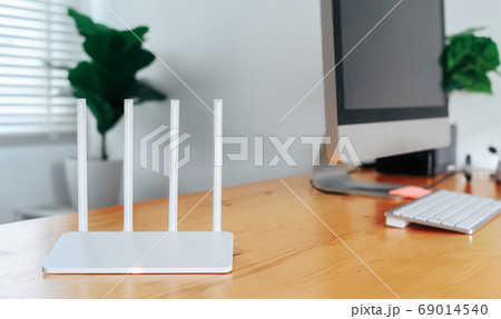 Modern Wi-Fi router on light table in home office 69014540