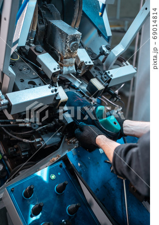 man working with automatic machinery on shoe factory 69014814