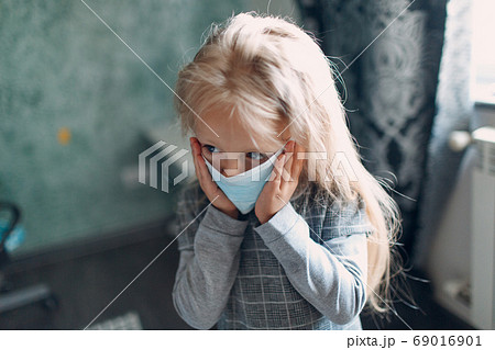 Little girl dressing uniform and putting face mask preparation back to school 69016901