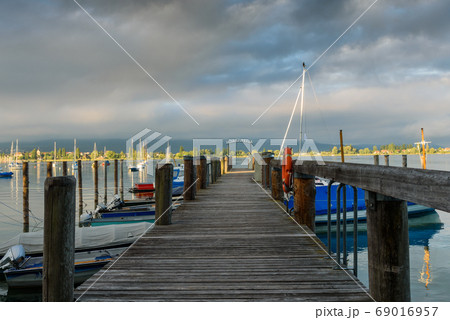 Jetty with boats in morning light. Allensbach, Lake Constance, Baden-Wuerttemberg, Germany Jetty with boats in morning light. Allensbach, Lake Constance, Baden-Wuerttemberg, Germany 69016957