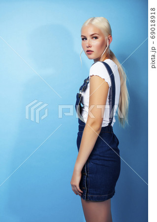 young pretty teenage modern hipster girl posing emotional happy on blue background, lifestyle people concept 69018918