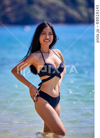 Beautiful asian woman posing on a tropical beach 69019145