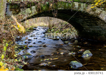A Water cascade in the creek flowing under an 69019741