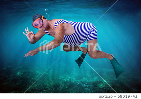 A man in retro swimsuit swims underwater 69019743