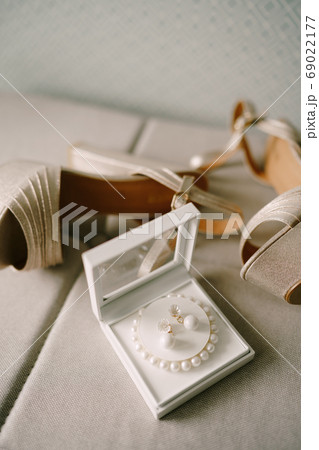 Mother-of-pearl women's sandals and a box with a bracelet of white beads and earrings. 69022177