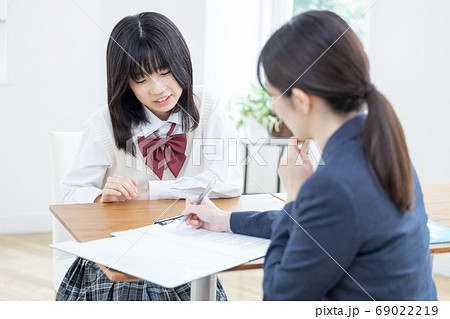 教育イメージ　面談中に落ち込む女子高生を励ます先生 69022219