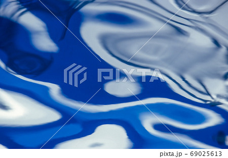 水面の揺らぎと反射が作る抽象画の写真素材