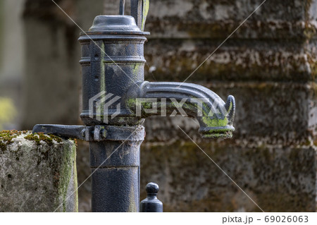 Hand pump in a graveyard 69026063