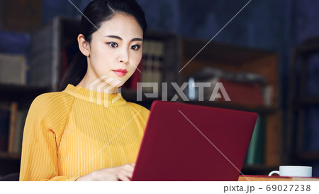 暗い部屋でpcを見る女性の写真素材
