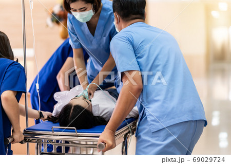 Medical team do CPR to injured patient on gurney Medical team do CPR to injured patient on gurney 69029724