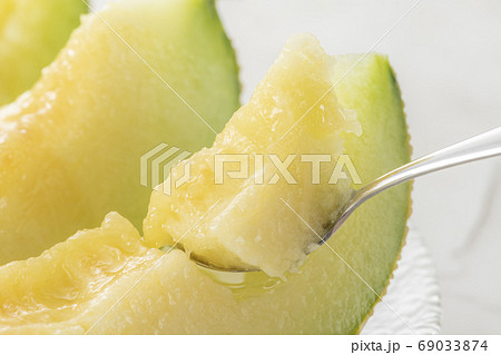 完熟したメロンをスプーンで食べる 69033874