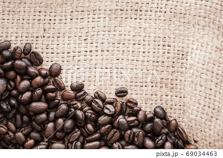 Roasted coffee beans lay over jute bag fabric. Flat lay 69034463