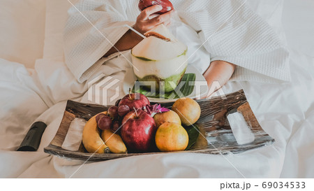 Picture of tourists eating fruits on the bed, health food concept Picture of tourists eating fruits on the bed, health food concept 69034533