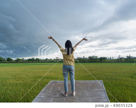 A tourist woman standing on balcony terrace and Asian paddy rice A tourist woman standing on balcony terrace and Asian paddy rice 69035328