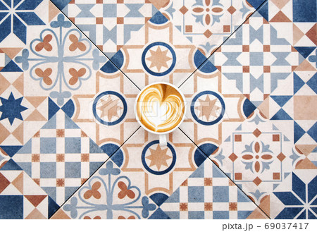 Cup of latte coffee on colorful tile background Cup of latte coffee on colorful tile background 69037417