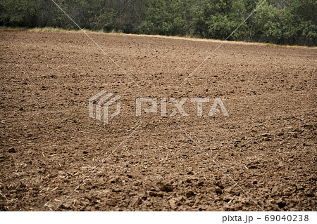 plowed field and blue sky, soil and clouds of a bright sunny day - concept of agriculture 69040238