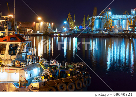view of the industrial port at night - ships waiting for loading and unloading, cargo transportation by sea view of the industrial port at night - ships waiting for loading and unloading, cargo transportation by sea 69040321