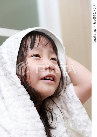 お風呂上がりにバスタオルで髪の毛を拭く女の子 69041757