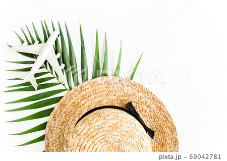 Traveler accessories concept on white background. Straw hat, model plane, airplane, sunglasses and tropical palm leaf. Summer background. Flat lay, 69042781