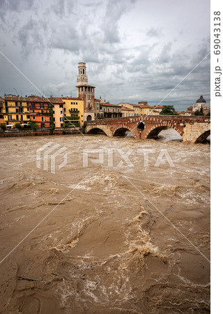 Ponte Pietra - Stone bridge and Adige river in flood - Verona Italy 69043138